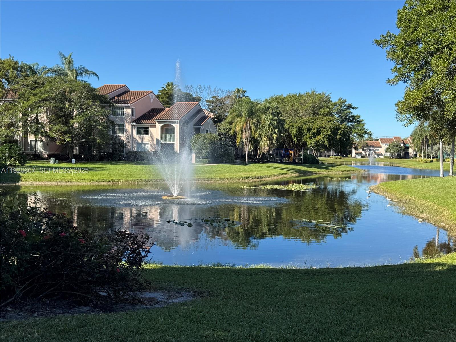 12124 St Andrews Place, Unit 206 Miramar, FL 33025 - Photo 19 of 20 a view of a lake with a house in the background