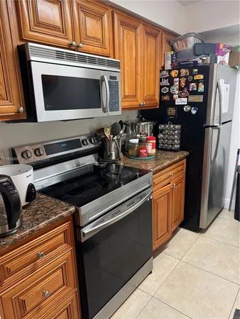 a kitchen with stainless steel appliances granite countertop a refrigerator and a stove top oven