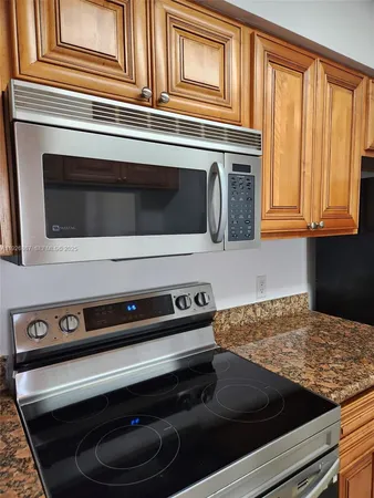a kitchen with wooden cabinets and a stove top oven
