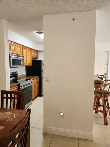 a kitchen with stainless steel appliances wooden floor and a refrigerator