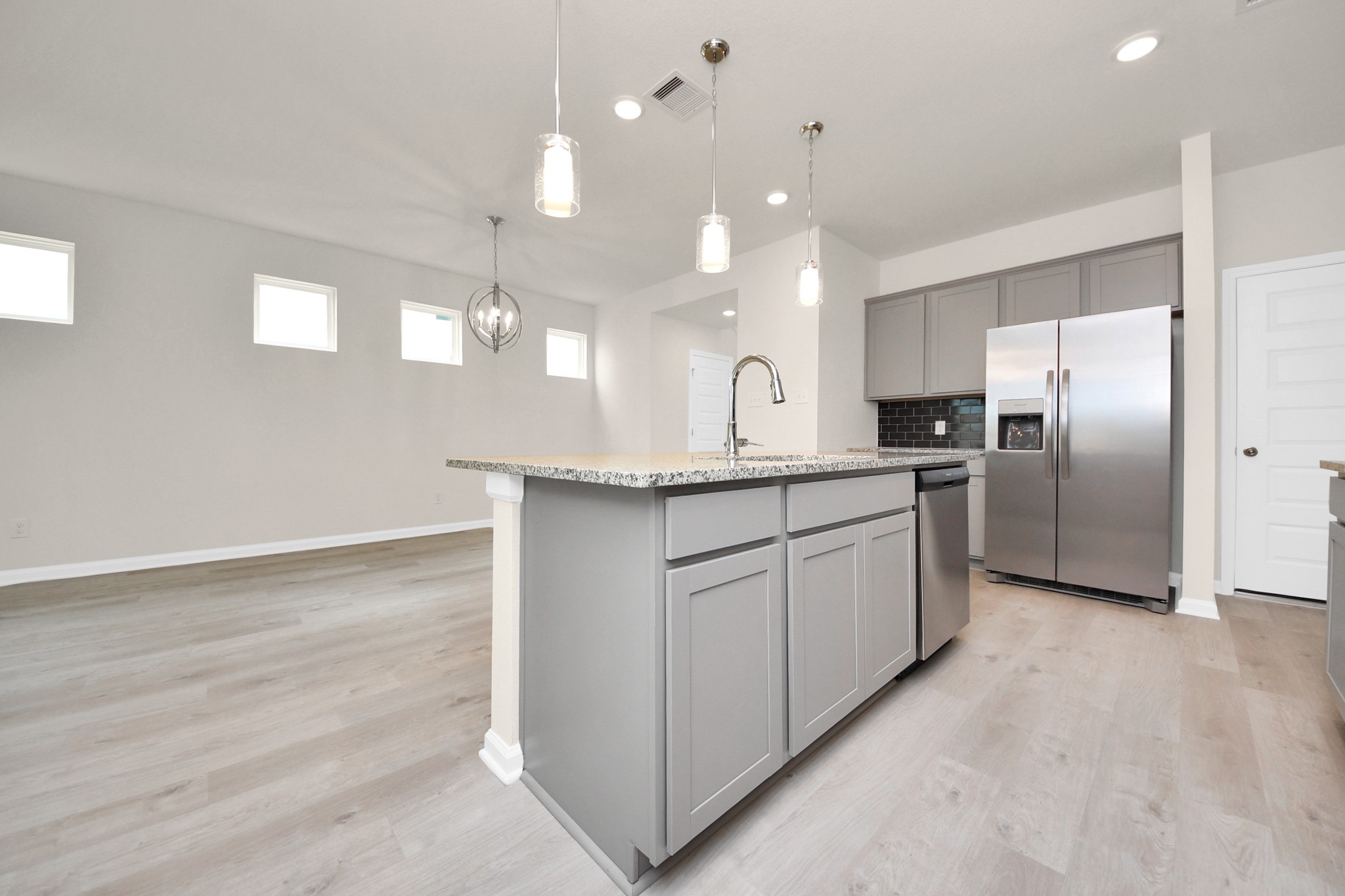 15523 Fathom Line Way Houston, TX 77053 - Photo 6 of 39 Luxury vinyl plank flooring extends seamlessly throughout the living areas and wet spaces, creating a cohesive look and enhancing the home's overall flow.