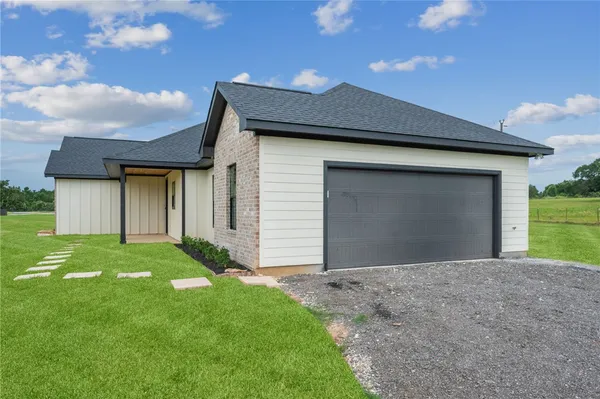 a front view of house with yard and garage