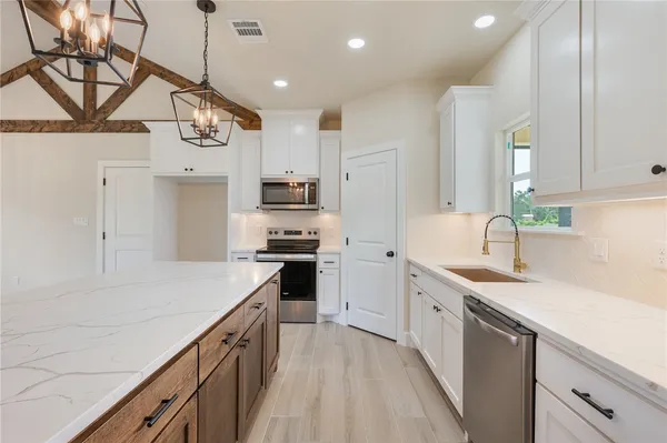 a very nice looking kitchen with granite countertop a stove oven and wooden floor