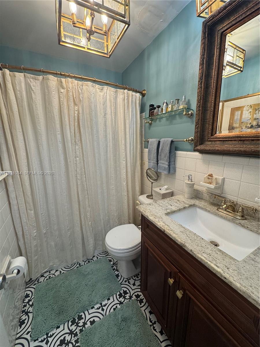 918 Southeast 16th Street, Unit 918 Deerfield Beach, FL 33441 - Photo 19 of 20 a bathroom with a granite countertop sink and a mirror