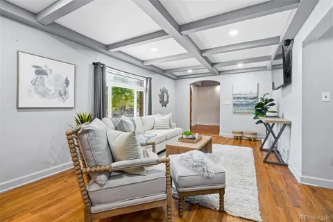 a living room with furniture and a wooden floor