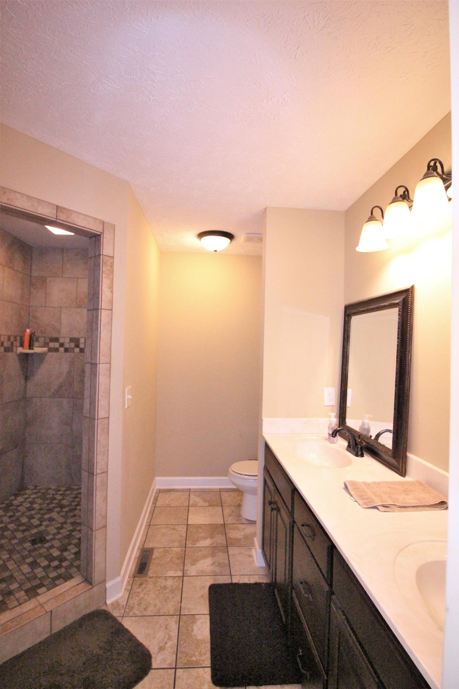 304 Williams Road Manchester, TN 37355 - Photo 11 of 20 a bathroom with a double vanity sink a toilet and a mirror