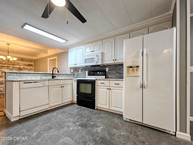 a kitchen with white cabinets and white appliances