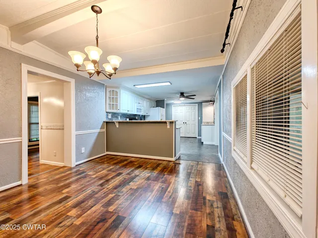 a view of a livingroom with a furniture wooden floor and chandelier