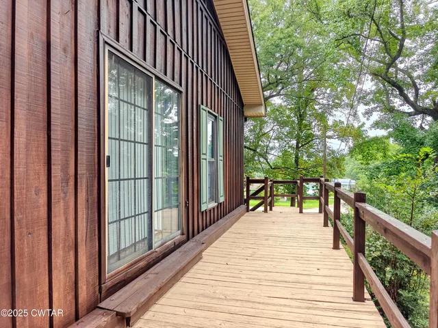 a view of a balcony with wooden floor and fence