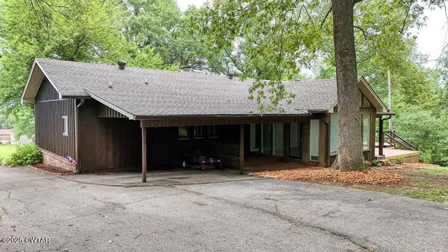 a view of a house with a tree in front of it