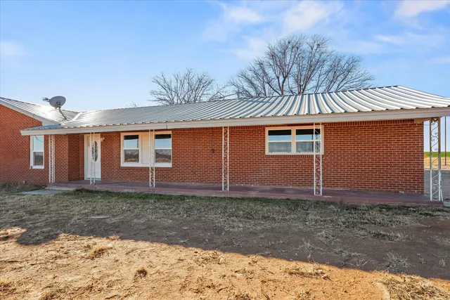 an empty room with a window and ceiling fan