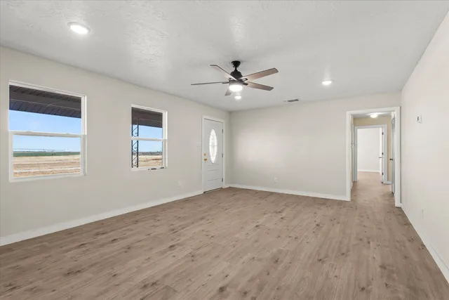 an empty room with a window and a ceiling fan