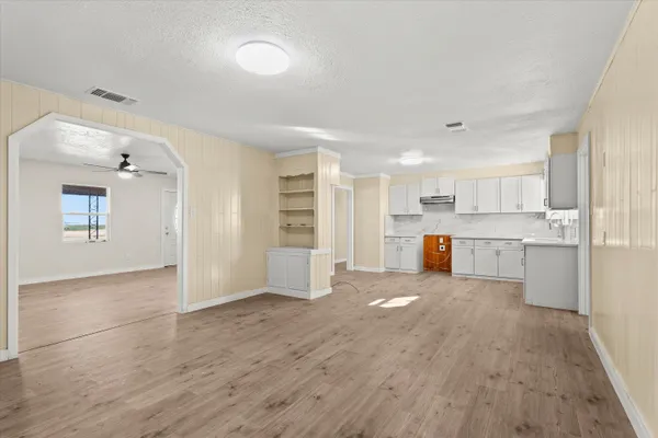 a view of a kitchen with wooden floor and electronic appliances