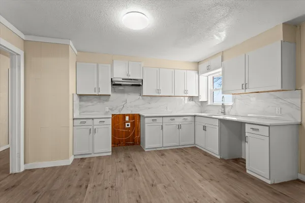 a kitchen with stainless steel appliances a sink cabinets and wooden floor