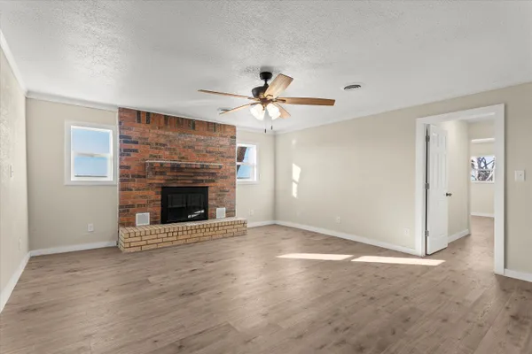 a view of a livingroom with a fireplace and a chandelier fan