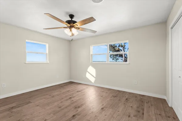 a view of a big room with wooden floor and windows