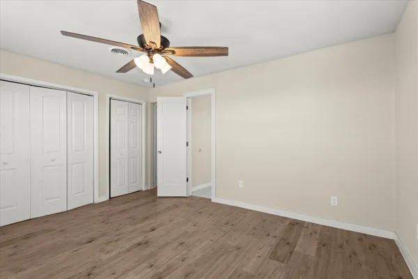 a view of a room with wooden floor and a ceiling fan