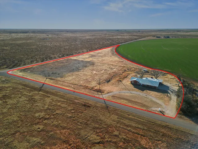an empty room with wooden floor and ceiling fan
