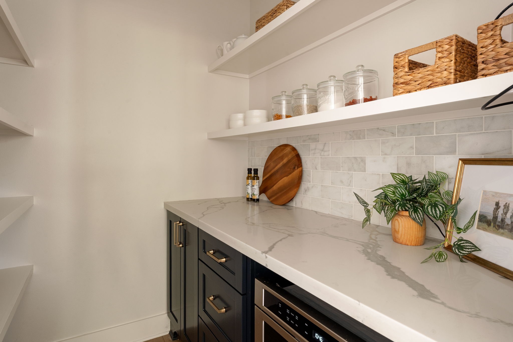 1022 Key Street Houston, TX 77009 - Photo 11 of 30 Tucked away for maximum organization is a massive walk-in butler’s pantry, complete with a dedicated coffee bar and built-in microwave, ensuring your counters stay clutter-free.
