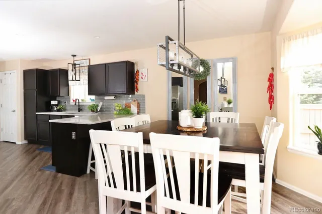 a dining room with furniture a chandelier and wooden floor
