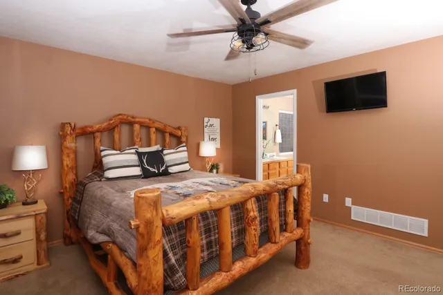 a bedroom with a bed a tv on the wall and a window