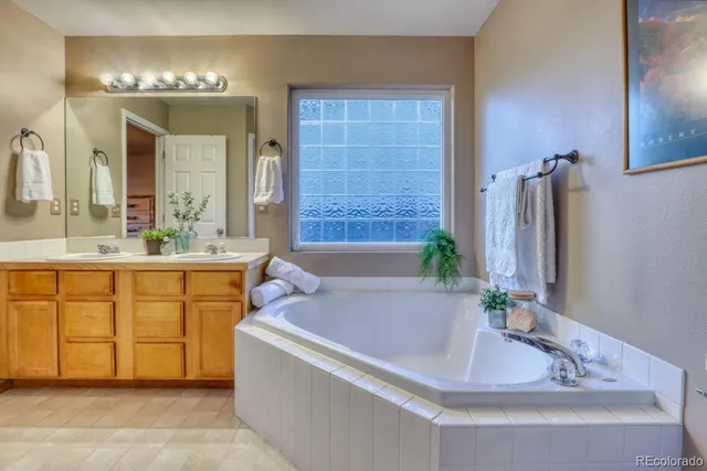 a bathroom with a tub sink and mirror