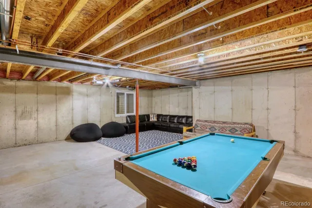 a backyard of a house with table and chairs under an umbrella