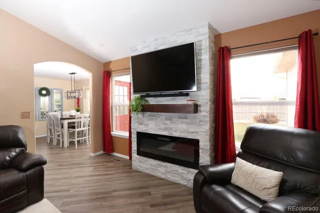 a living room with furniture a flat screen tv and a fireplace