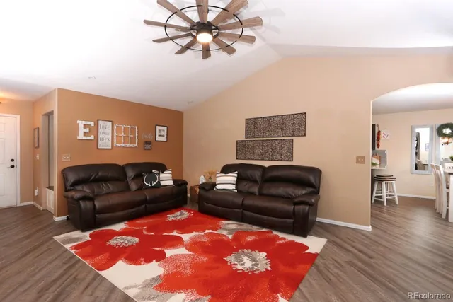 a living room with furniture and a wooden floor
