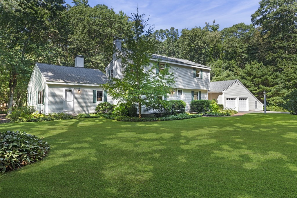 a front view of house with a garden and trees