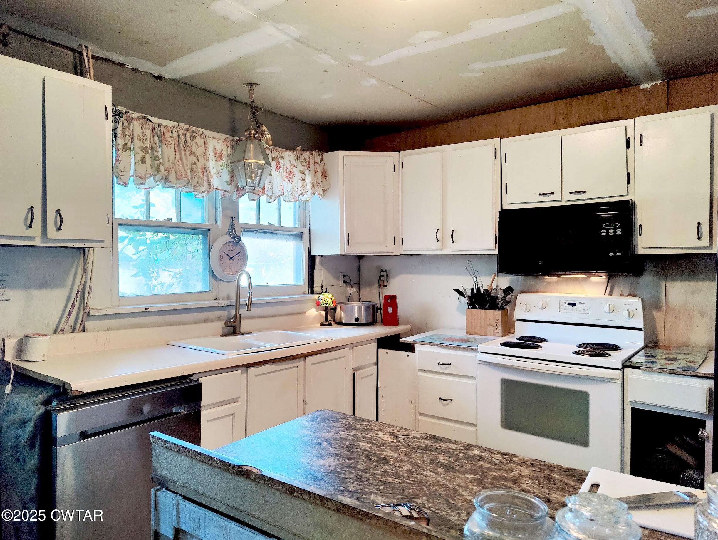 533 East 3rd Street Trenton, TN 38382 - Photo 5 of 12 a kitchen with stainless steel appliances white cabinets a sink and a stove