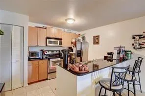 a kitchen with stainless steel appliances kitchen island granite countertop a refrigerator and microwave