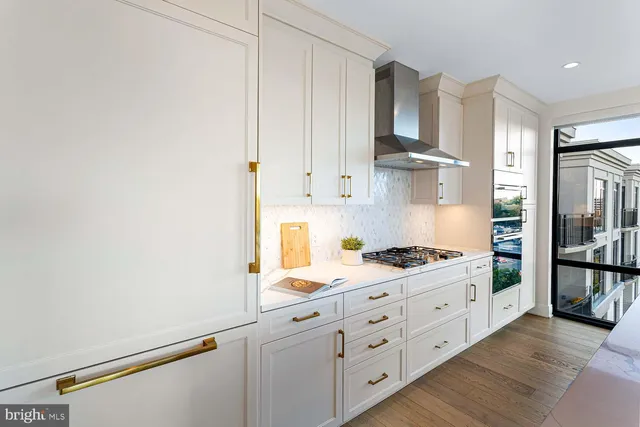 a large white kitchen with a large window