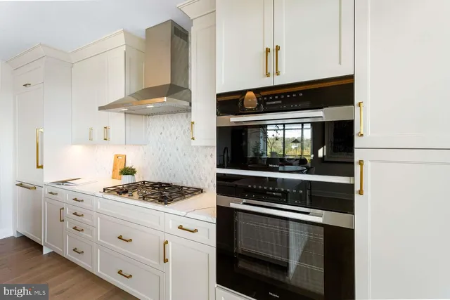 a kitchen with granite countertop white cabinets and stainless steel appliances