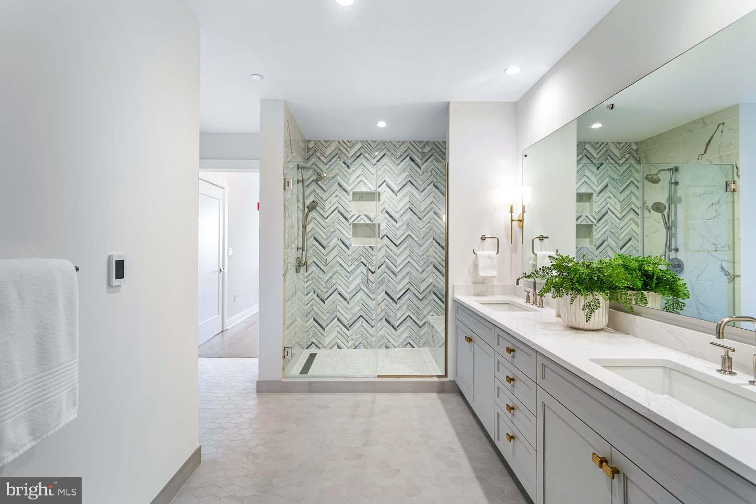 6718 Lowell Avenue, Unit 702 McLean, VA 22101 - Photo 28 of 75 a bathroom with a granite countertop sink a mirror a vanity and a shower