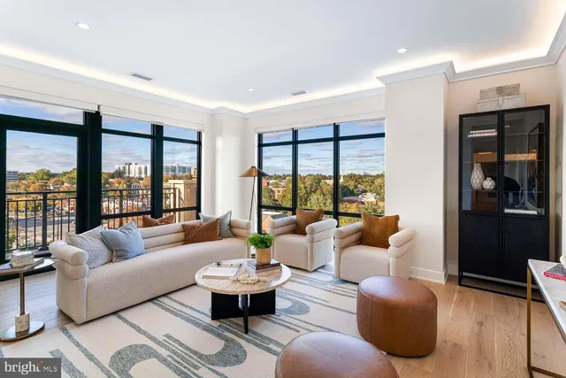 a living room with furniture and floor to ceiling windows
