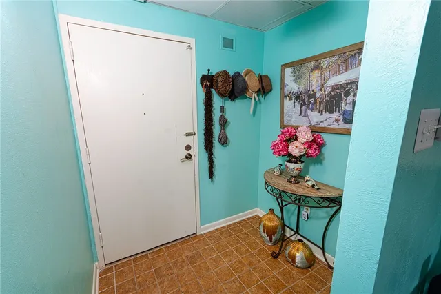 a view of a hallway with furniture and flowers