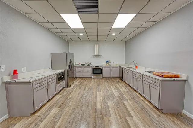 a kitchen with stainless steel appliances granite countertop a sink and wooden floors