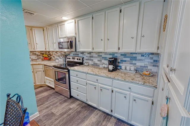 a kitchen with white cabinets and white appliances