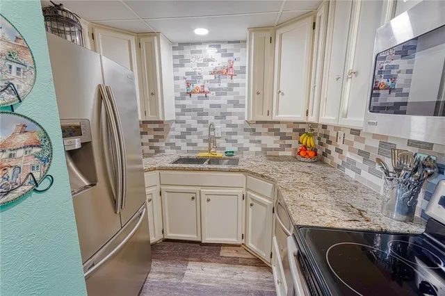 a kitchen with stainless steel appliances granite countertop a refrigerator sink and stove