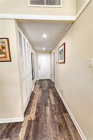 a view of a hallway with wooden floor and staircase