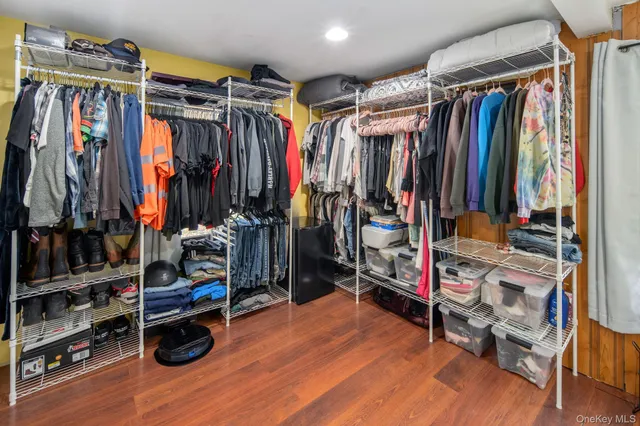 a view of walk in closet with clothes and shoes