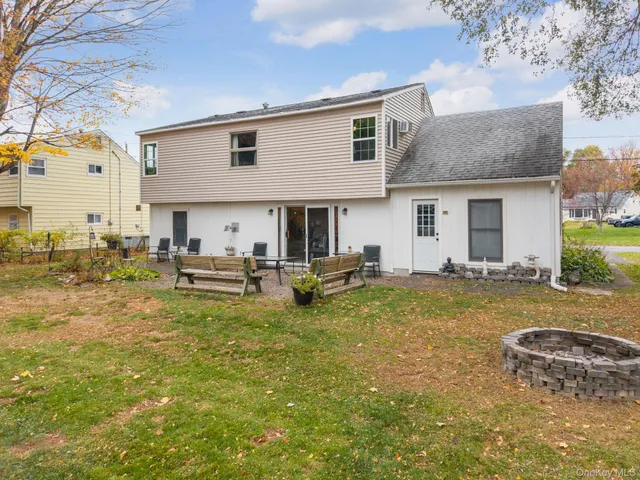 a view of swimming pool with outdoor seating and house in the background