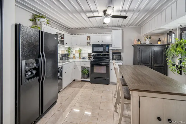 a kitchen with stainless steel appliances granite countertop a refrigerator a stove and a sink with cabinets