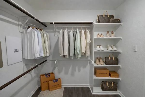 a view of walk in closet with clothes and shoes