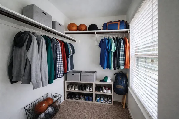 a view of walk in closet with clothes and shoes