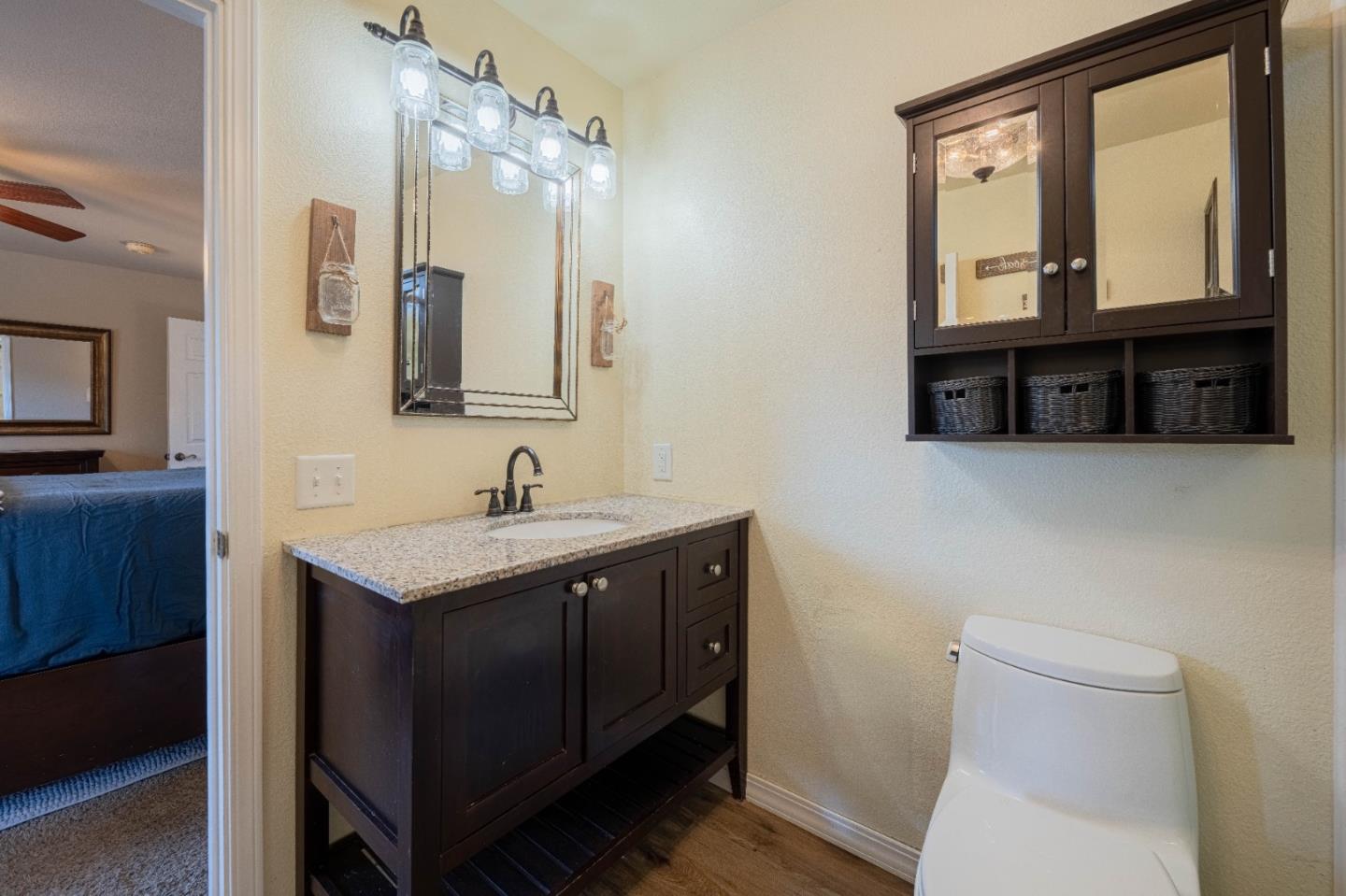 143 Tucker Road Watsonville, CA 95076 - Photo 24 of 42 a bathroom with a toilet a sink a mirror and a window