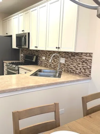 a kitchen with granite countertop white cabinets and white appliances