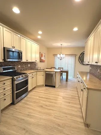 a kitchen with cabinets appliances and a window