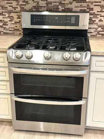 a view of a kitchen with granite countertop white cabinets and a wooden floor